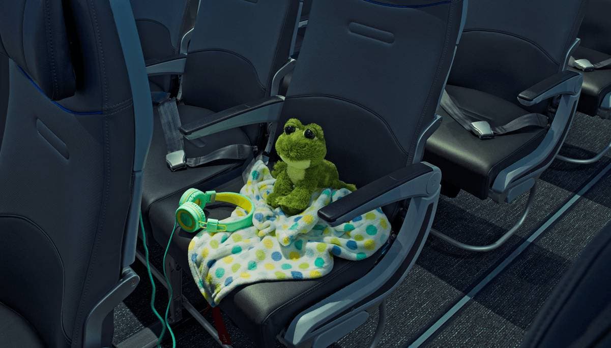 stuffed animal frog with blanket and headphones on seat
