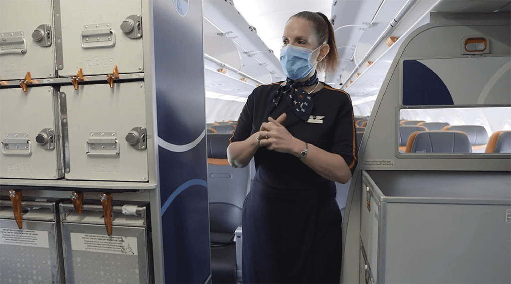 Inflight Crewmember in the aisle with mask